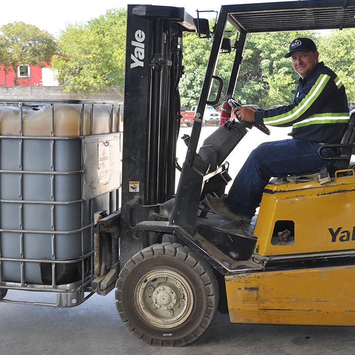Man driving forklift with bulk lubricans